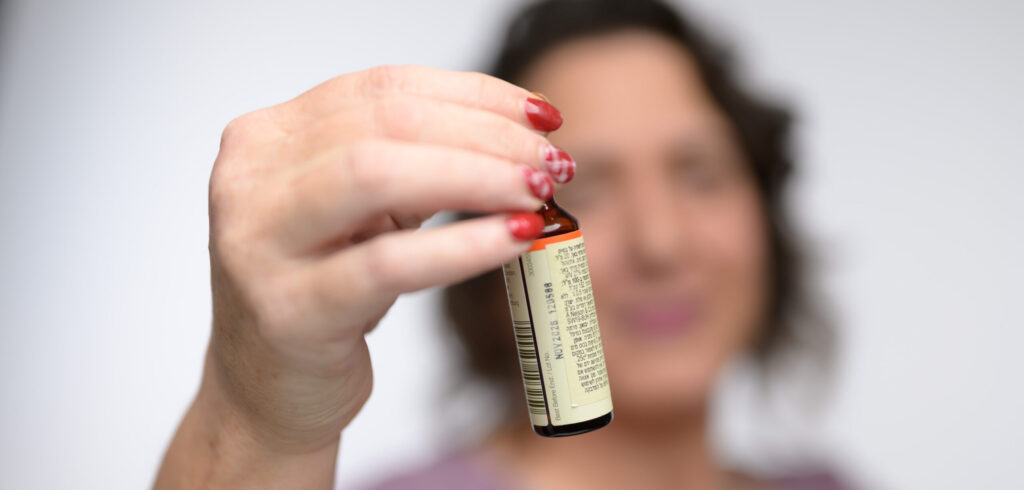 טיפול טבעי בדלקות אזניים - רביד מחזיקה בקבוקון תמצית פרחי באך