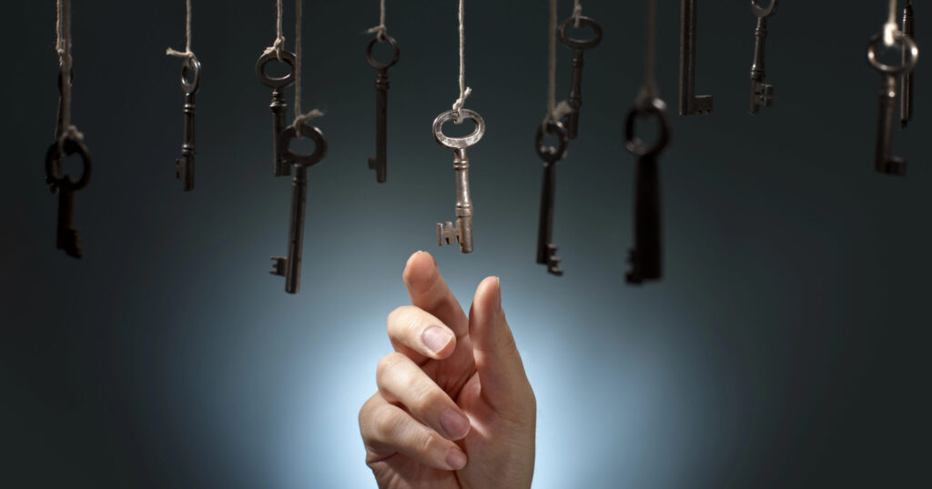 יד מושטת לקחת מפתח אחד מואר מתוך כמה מפתחות שתלויים באוויר, קבלת החלטות במיטבה