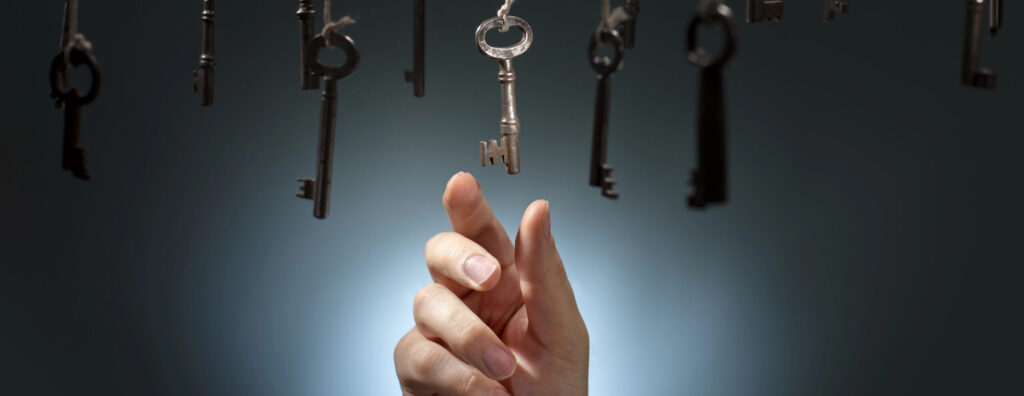 יד מושטת לקחת מפתח אחד מואר מתוך כמה מפתחות שתלויים באוויר, קבלת החלטות במיטבה