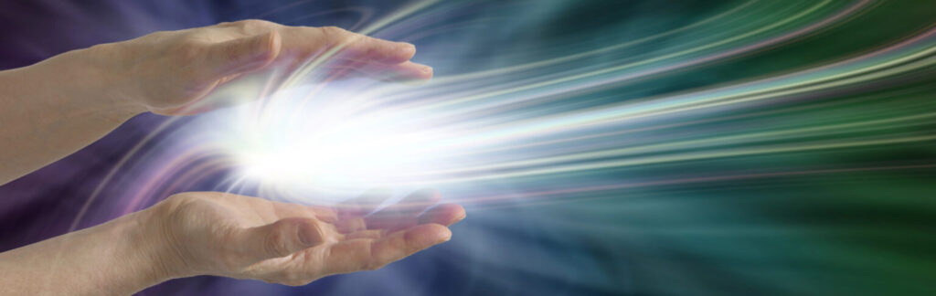 אור בוקע מתוך כפות ידיים. רפואה משלימה כטיפול אנרגטי