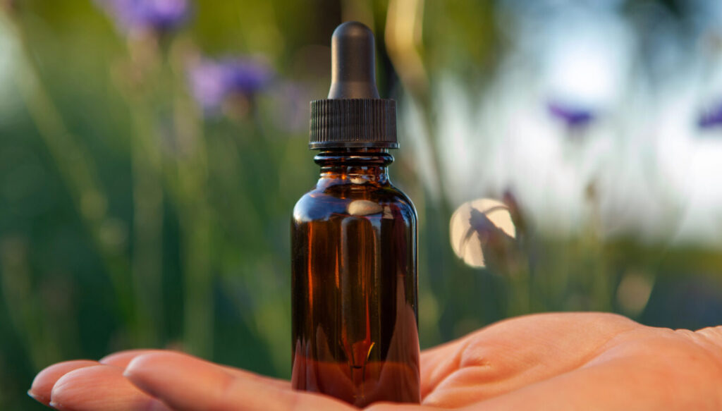 בקבוק תמציות מונח על כף יד - טיפול טבעי בילדים 